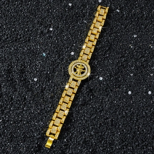 Dettaglio del bracciale hip-hop dorato con pendente girevole e cristalli scintillanti