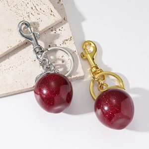 Porte-clés élégant avec boule en résine rouge pailletée et fermoir mousqueton