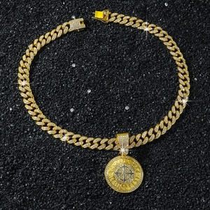 Détail du collier chaîne cubaine dorée avec pendentif boussole serti de diamants