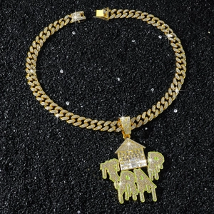 Detail der Hip-Hop Goldkette mit TRAP Haus Anhänger auf dunklem Steinhintergrund