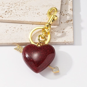 Porte-clés cœur en résine rouge pailletée avec flèche dorée et strass brillants