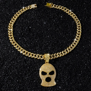 Macro view of iced-out skull pendant on a Cuban link chain with gold and white rhinestones
