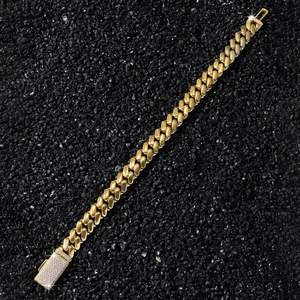 Bracelet gourmette doré pour homme avec boucle en zircone brillant sur fond de pierres