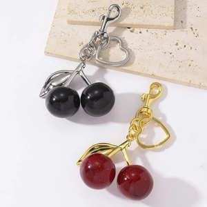 Resin cherry heart keychains in black glossy and red glitter finishes with metal clasps