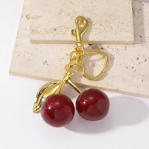 Resin cherry heart keychain with pearlescent red finish and golden metal heart ring