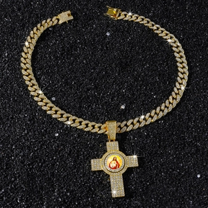Detailaufnahme des vergoldeten Kreuzanhängers mit Jesus-Porträt und Iced Out-Kubakette