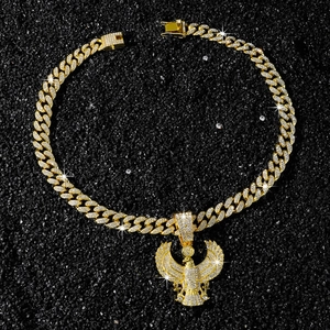 Close-up of iced-out Cuban link chain featuring a golden eagle pendant with crystals