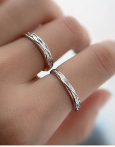 Macro shot of S925 sterling silver couple rings with irregular wavy textured details