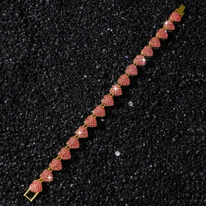 Detail of gold heart-shaped link bracelet with micro-pave pink rhinestones and metal clasp