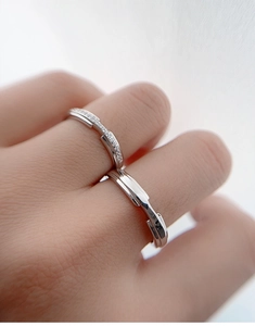 Close-up of minimalist geometric silver rings with fine diamond inlay on hand