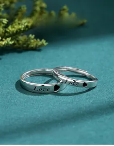 Macro close-up of S925 silver couple rings featuring Love engraving and heart motif