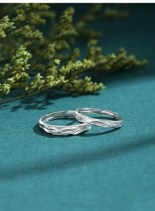 Macro detail of S925 sterling silver couple rings with elegant wave pattern texture