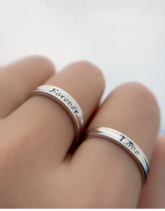 Macro detail of S925 sterling silver rings with Forever Love engraving for couples