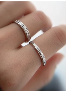 Detailed macro view of S925 sterling silver couple rings with wavy textured surface