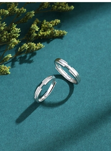 Close-up of S925 sterling silver couple rings with sparkling pavé diamonds and smooth finish
