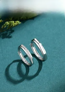 Gros plan de bagues de couple en argent S925 avec zircons et facettes géométriques