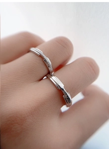 Close-up of minimalist S925 sterling silver couple rings set with sparking small diamonds