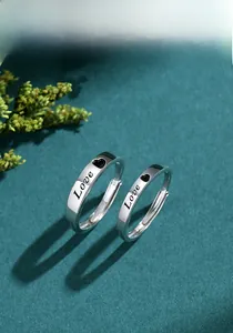 Detailed shot of S925 silver couple rings featuring Love engraving and heart motif