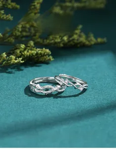 Close-up of S925 silver twig couple rings with zircons on dark green nature texture
