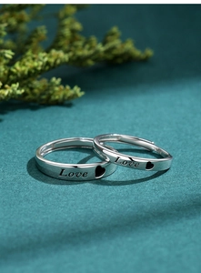 Detail of S925 sterling silver couple rings with Love engraving and heart motif