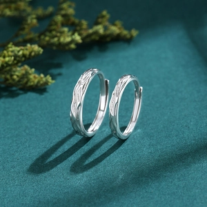 Minimalist S925 sterling silver couple rings with textured wavy finish on green background