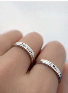 Macro shot of silver S925 rings featuring Forever and Love engraved inscriptions