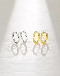 Detailed view of silver and gold S925 Mobius twist earrings with smooth polished finish