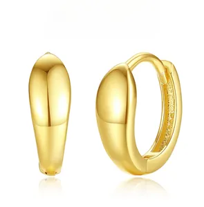 Detailed view of polished golden teardrop hoop earrings with elegant mirror finish on white background