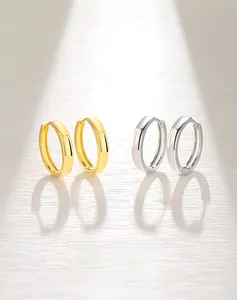 Detail of minimalist S925 silver hoop earrings in polished gold and silver finishes