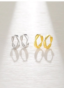 Close-up of polished S925 sterling silver Mobius hoop earrings in gold and silver