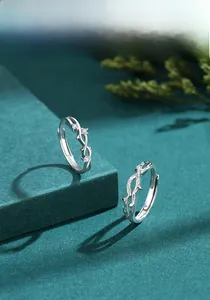 Macro detail of S925 sterling silver branch rings with zircon stones on green stand