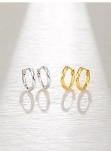 Macro detail of twisted Mobius hoop earrings in silver and gold minimalist finishes