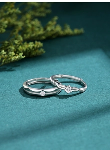 Macro detail of S925 silver couple rings featuring sparkling round cut solitaire diamonds