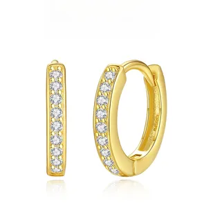 Detailed close-up of gold Huggie earrings with double rows of sparkling white zircons