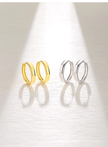 Detail view of gold and silver S925 sterling silver hoop earrings with mirror polished finish