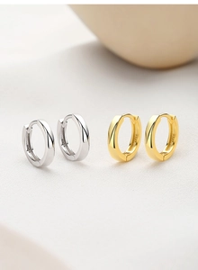 Detailed close-up of S925 sterling silver stamp on gold and silver hoop earrings