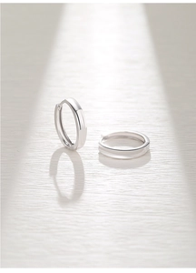 Detailed macro view of polished S925 sterling silver hoop earrings with metallic luster