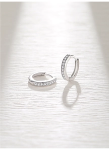 Macro shot of silver huggie earrings featuring micro-pave cubic zirconia on S925 silver