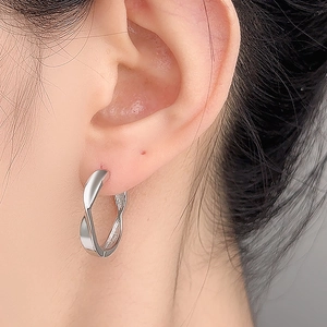 S925 sterling silver Mobius twist hoop earrings worn on ear with high mirror polish