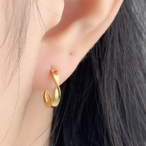 Elegant 925 sterling silver golden twisted hoop earrings shown on a model