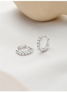 Macro shot of S925 sterling silver huggie earrings featuring row of sparkling zircons