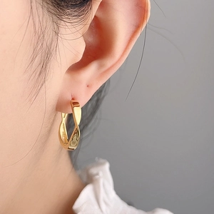 Minimalist S925 silver Mobius hoop earrings in gold finish worn by a model
