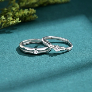 S925 sterling silver couple rings with round cut diamonds on a dark textured background