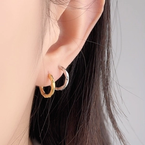 Elegant Mobius hoop earrings in gold and silver finish on a model for daily wear