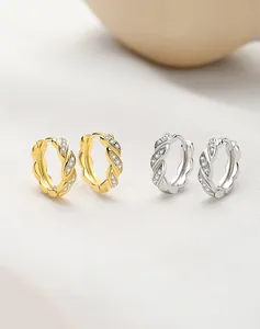 Makroaufnahme von S925 Sterlingsilber-Ohrringen in Gold und Silber mit Zirkonia-Besatz