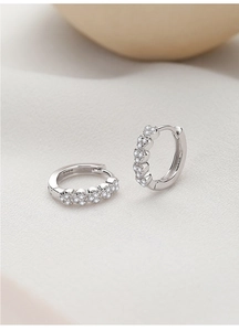 Gros plan de boucles d'oreilles en argent S925 avec micro-pavé de zircons sur satin
