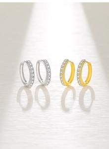 Dettaglio macro di orecchini a cerchio in argento S925 in finitura oro e argento