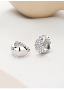 Macro shot of S925 sterling silver huggie earrings with pave-set zircons and mirror polish