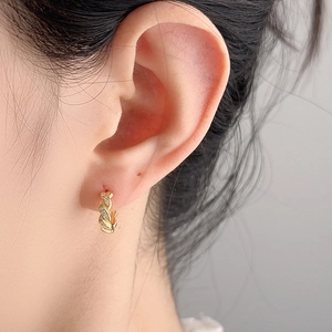 Gedrehte goldene Creolen mit Zirkonia-Besatz an einem Model für einen schlichten Alltagslook