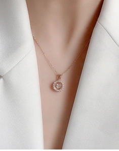 Close-up of rose gold necklace featuring a spinning moissanite pendant on a model